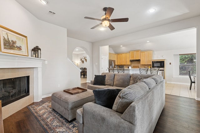 107 Barkley Dr, Hickory Creek, TX 75065 - living room featuring arched walkways, ceiling fan, dark wood-style floors, a tile fireplace, and recessed lighting
