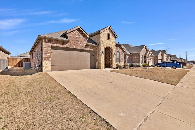 10407 Twisting Springs Dr, Aubrey, TX 76227 - french country inspired facade featuring brick siding, an attached garage, driveway, stone siding, and central AC