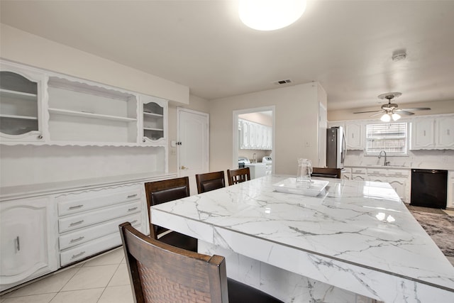 9718 Burney Dr, Dallas, TX 75243 - kitchen featuring dishwasher, freestanding refrigerator, white cabinetry, a sink, and light stone countertops