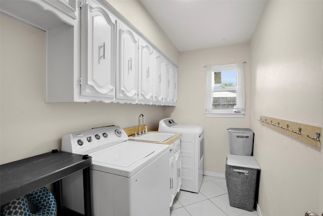 9718 Burney Dr, Dallas, TX 75243 - washroom with washer and clothes dryer, baseboards, light tile patterned floors, and cabinet space