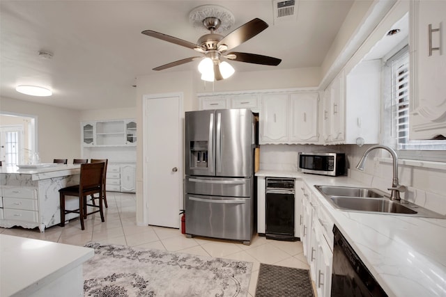 9718 Burney Dr, Dallas, TX 75243 - kitchen featuring appliances with stainless steel finishes, plenty of natural light, white cabinets, and a sink