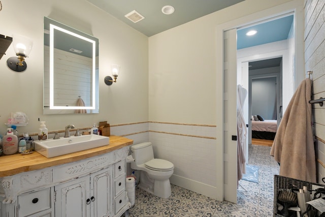 1234 Shelby Ln, Celina, TX 75009 - bathroom featuring vanity, tile walls, wainscoting, and recessed lighting