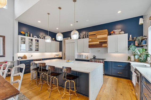 1234 Shelby Ln, Celina, TX 75009 - kitchen featuring a kitchen island, stainless steel appliances, light wood finished floors, a kitchen breakfast bar, and recessed lighting
