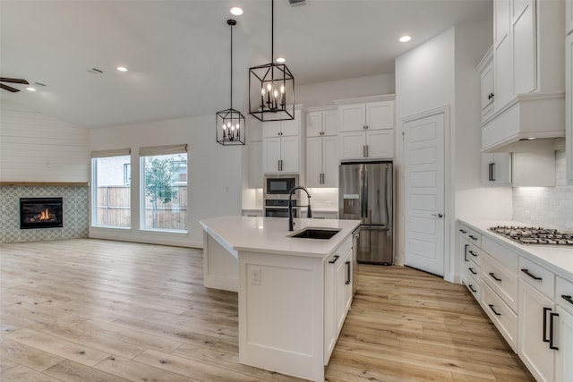 8235 Ottowa Rdg, Frisco, TX 75034 - kitchen with appliances with stainless steel finishes, a sink, light wood-style flooring, light countertops, and open floor plan