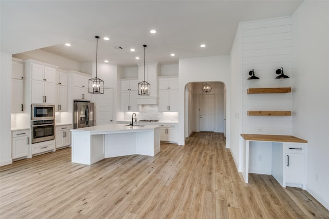 8235 Ottowa Rdg, Frisco, TX 75034 - kitchen featuring appliances with stainless steel finishes, a sink, decorative backsplash, light countertops, and light wood-type flooring
