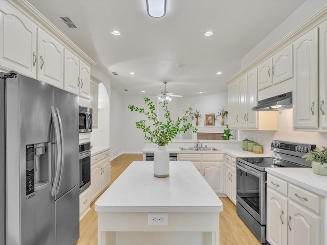 1536 Valley Creek Rd, Denton, TX 76205 - kitchen with stainless steel appliances, under cabinet range hood, a ceiling fan, a kitchen island, and light wood-style floors