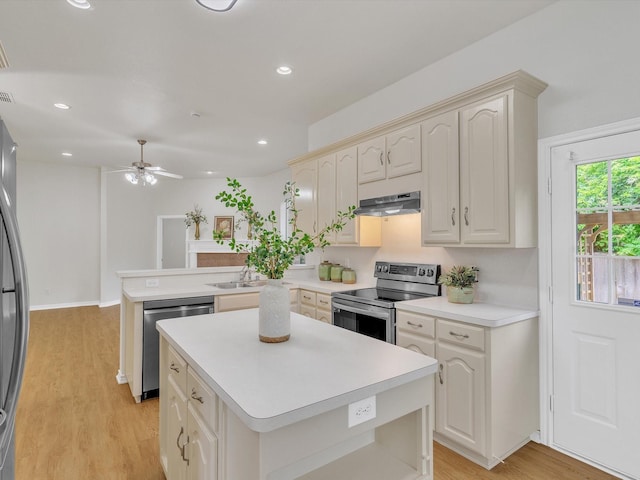 1536 Valley Creek Rd, Denton, TX 76205 - kitchen with appliances with stainless steel finishes, a peninsula, light wood finished floors, a kitchen island, and ceiling fan