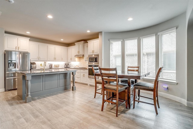 240 Gill Point Ln, Aledo, TX 76008 - kitchen with stainless steel appliances, light stone countertops, tasteful backsplash, under cabinet range hood, and white cabinets