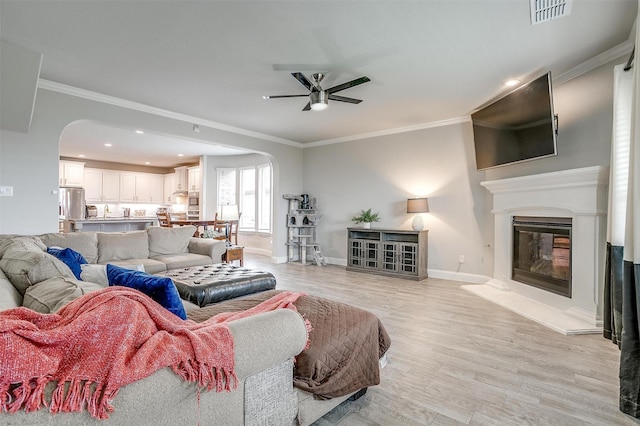 240 Gill Point Ln, Aledo, TX 76008 - living room with arched walkways, ceiling fan, crown molding, light wood-type flooring, and baseboards