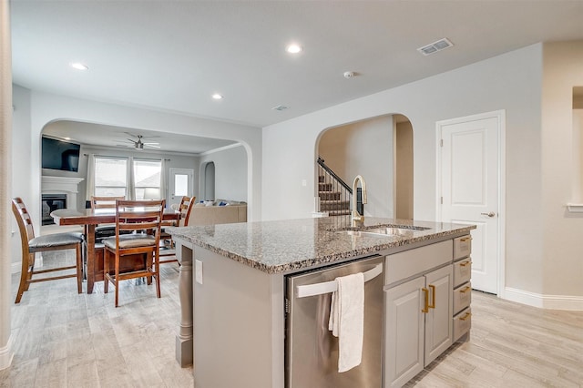 240 Gill Point Ln, Aledo, TX 76008 - kitchen with dishwasher, a sink, a ceiling fan, arched walkways, and light stone countertops