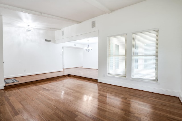 3113 E Park Blvd, Plano, TX 75074 - empty room with a chandelier, beamed ceiling, wood finished floors, and baseboards