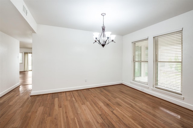3113 E Park Blvd, Plano, TX 75074 - spare room featuring a chandelier, baseboards, and wood finished floors