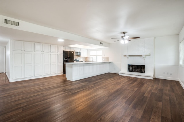 3113 E Park Blvd, Plano, TX 75074 - unfurnished living room with a ceiling fan, dark wood-style floors, a brick fireplace, and baseboards