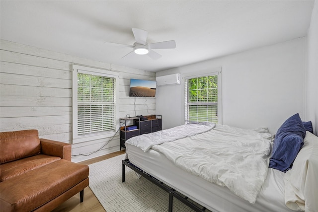 604 N Benge St, Mckinney, TX 75069 - bedroom featuring an AC wall unit, multiple windows, wood finished floors, and ceiling fan