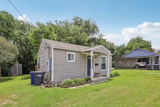 604 N Benge St, Mckinney, TX 75069 - view of front of house featuring an outbuilding, a front lawn, a carport, and a shingled roof