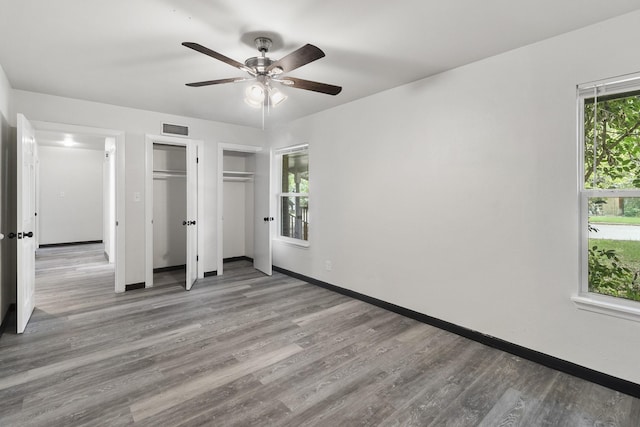 224 Brown Trl, Hurst, TX 76053 - unfurnished bedroom featuring wood finished floors, multiple closets, baseboards, and ceiling fan
