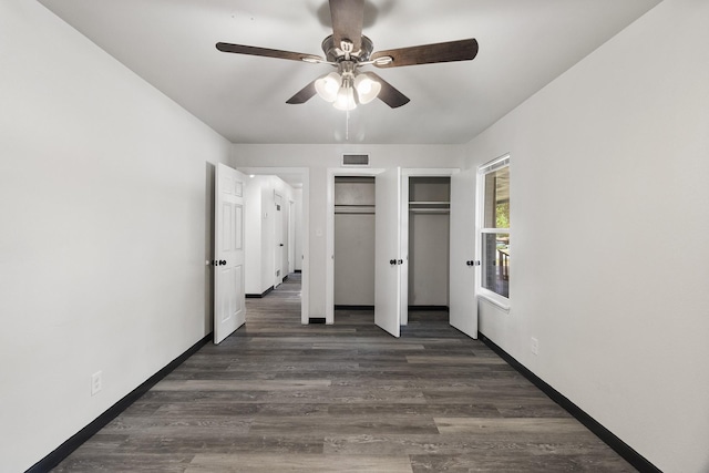 224 Brown Trl, Hurst, TX 76053 - unfurnished bedroom with wood finished floors, baseboards, a ceiling fan, and two closets