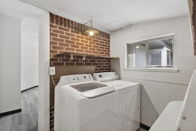 224 Brown Trl, Hurst, TX 76053 - laundry room with washer and dryer, wood finished floors, and brick wall