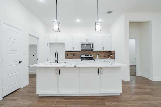 4507 Metropolitan Ave, Dallas, TX 75210 - kitchen featuring stainless steel microwave, range with electric cooktop, a sink, wood finished floors, and white cabinets