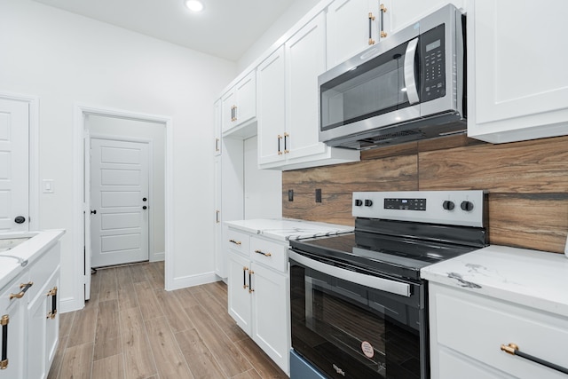 4507 Metropolitan Ave, Dallas, TX 75210 - kitchen featuring stainless steel appliances, white cabinetry, light stone counters, light wood-style flooring, and recessed lighting