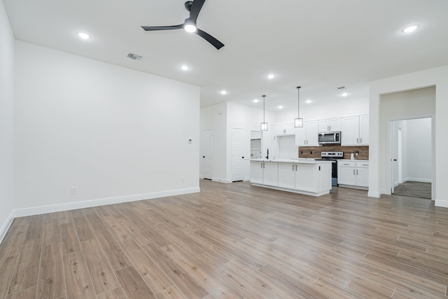 4507 Metropolitan Ave, Dallas, TX 75210 - unfurnished living room featuring ceiling fan, baseboards, light wood-style floors, recessed lighting, and a sink