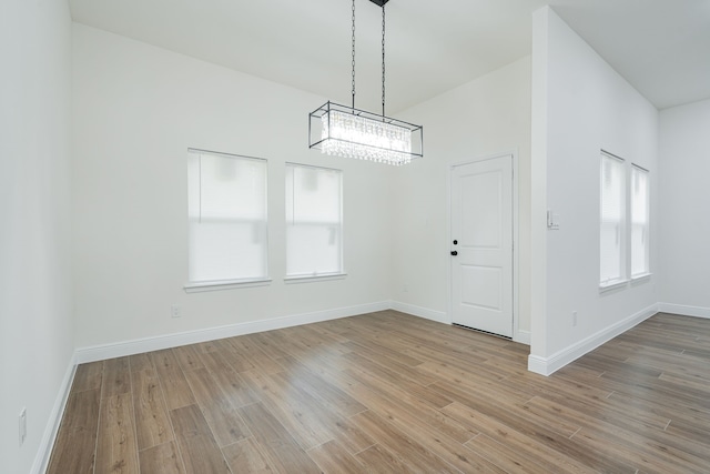 4507 Metropolitan Ave, Dallas, TX 75210 - unfurnished dining area featuring a chandelier, wood finished floors, and baseboards
