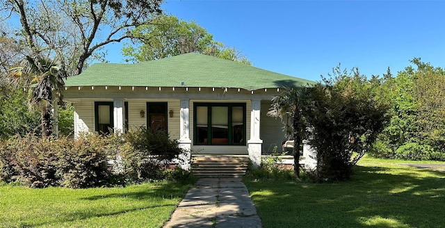 305 Quitman St, Pittsburg, TX 75686 - bungalow-style house featuring a porch, a front lawn, and roof with shingles