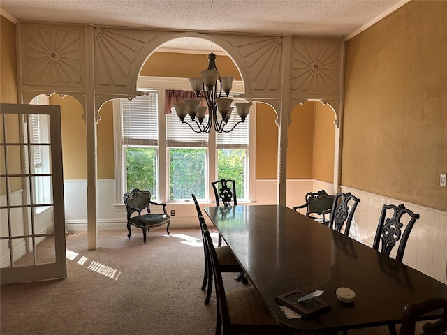 305 Quitman St, Pittsburg, TX 75686 - dining room featuring a chandelier, carpet floors, a textured ceiling, a wainscoted wall, and crown molding