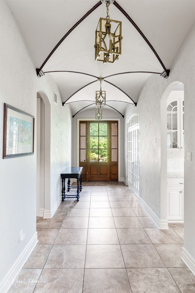 187 Waters Edge Dr, Shreveport, LA 71106 - foyer entrance featuring vaulted ceiling, arched walkways, a chandelier, baseboards, and a textured wall