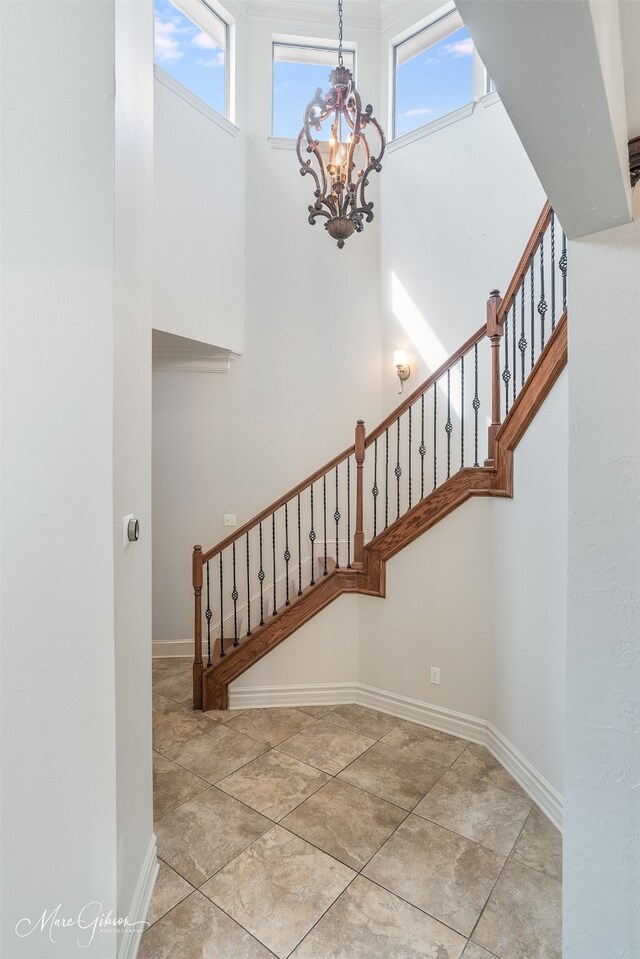 187 Waters Edge Dr, Shreveport, LA 71106 - staircase with a chandelier, baseboards, tile patterned flooring, and a high ceiling