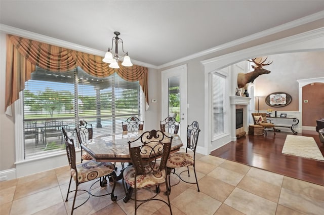 175 Robnett Rd, Waxahachie, TX 75165 - dining space with crown molding, a chandelier, light tile patterned floors, a glass covered fireplace, and baseboards