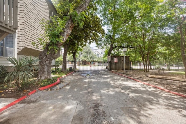 4837 Cedar Springs Rd Unit 321, Dallas, TX 75219 - view of asphalt street featuring curbs, a gate, and a gated entry