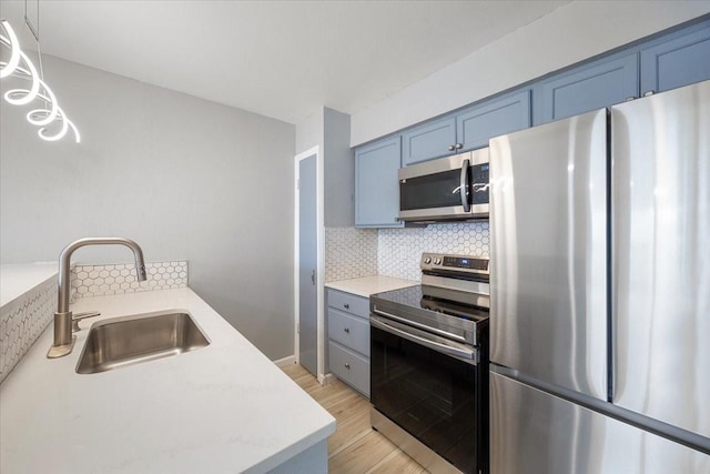 4837 Cedar Springs Rd Unit 321, Dallas, TX 75219 - kitchen featuring appliances with stainless steel finishes, tasteful backsplash, light countertops, and light wood-style flooring
