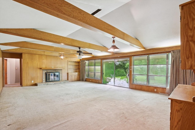 7200 Brooks Ave, Richland Hills, TX 76118 - unfurnished living room featuring wooden walls, a fireplace, healthy amount of natural light, light colored carpet, and ceiling fan