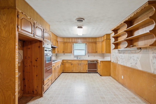 7200 Brooks Ave, Richland Hills, TX 76118 - kitchen with light floors, a warming drawer, light countertops, brown cabinets, and stainless steel oven