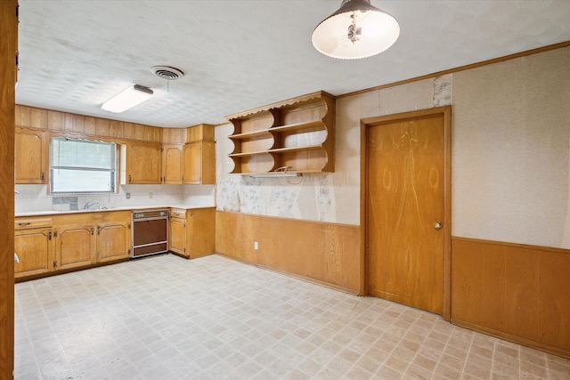 7200 Brooks Ave, Richland Hills, TX 76118 - kitchen with light floors, dishwashing machine, a wainscoted wall, light countertops, and brown cabinets