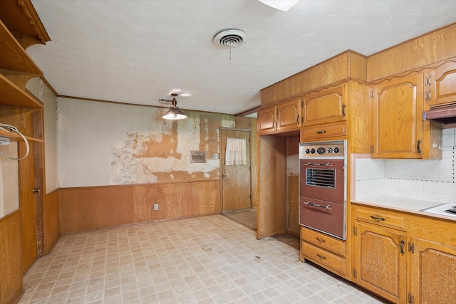 7200 Brooks Ave, Richland Hills, TX 76118 - kitchen with wall oven, light flooring, light countertops, wooden walls, and tasteful backsplash