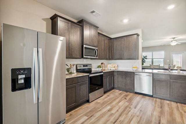 203 Lake Rdg, Princeton, TX 75407 - kitchen featuring stainless steel appliances, a sink, dark brown cabinets, light stone countertops, and recessed lighting