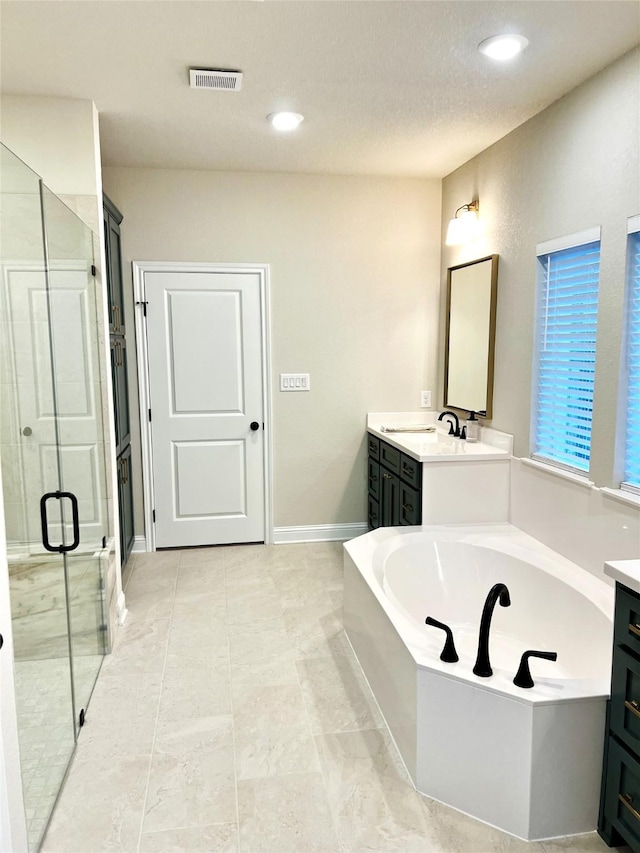 358 Frederick Dr, Robinson, TX 76706 - full bathroom with vanity, a garden tub, a stall shower, recessed lighting, and baseboards