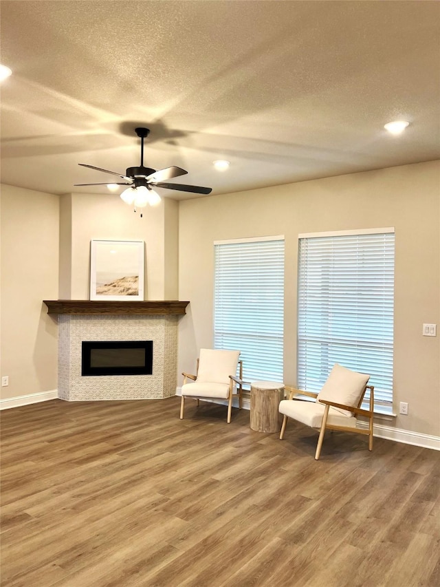 358 Frederick Dr, Robinson, TX 76706 - sitting room with wood finished floors, baseboards, a textured ceiling, a glass covered fireplace, and ceiling fan