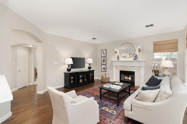 1405 San Mateo Dr, Allen, TX 75013 - living room featuring a tile fireplace, arched walkways, wood finished floors, and baseboards