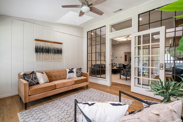 6737 Lake Shore Dr, Garland, TX 75044 - living room featuring a ceiling fan, wood finished floors, and a decorative wall