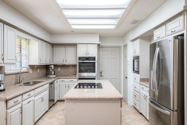 6737 Lake Shore Dr, Garland, TX 75044 - kitchen featuring stainless steel appliances, a kitchen island, tasteful backsplash, light tile patterned floors, and light stone countertops