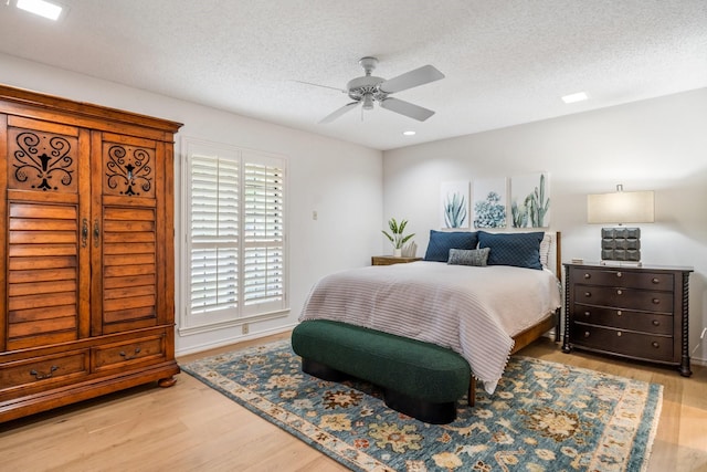 6737 Lake Shore Dr, Garland, TX 75044 - bedroom featuring wood finished floors, a textured ceiling, and a ceiling fan