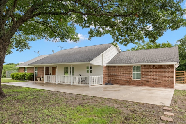 2144 County Road 4535, Whitewright, TX 75491 - rear view of house featuring brick siding, a shingled roof, a lawn, and a patio