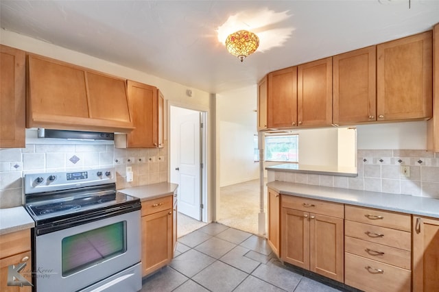 25 Spears Cir, Abilene, TX 79601 - kitchen featuring stainless steel electric range, light countertops, backsplash, light tile patterned floors, and light carpet