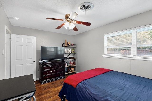 5405 Westhaven Dr, Fort Worth, TX 76132 - bedroom with dark wood-style flooring, multiple windows, a ceiling fan, and a textured ceiling