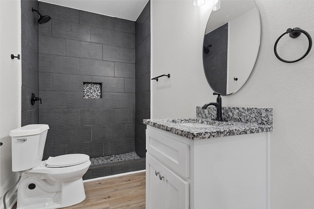 1608 N 17th St, Waco, TX 76707 - bathroom featuring toilet, vanity, tiled shower, and wood finished floors