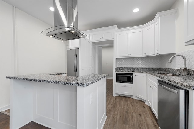 1608 N 17th St, Waco, TX 76707 - kitchen with island exhaust hood, stainless steel appliances, a sink, dark wood-style flooring, and white cabinetry