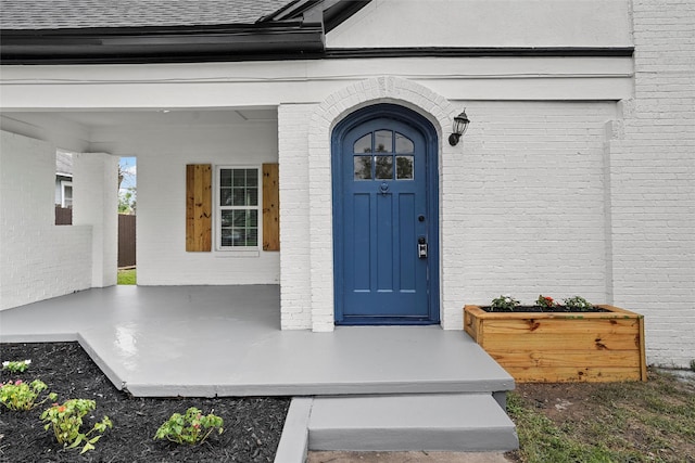 1608 N 17th St, Waco, TX 76707 - view of exterior entry featuring brick siding and a shingled roof